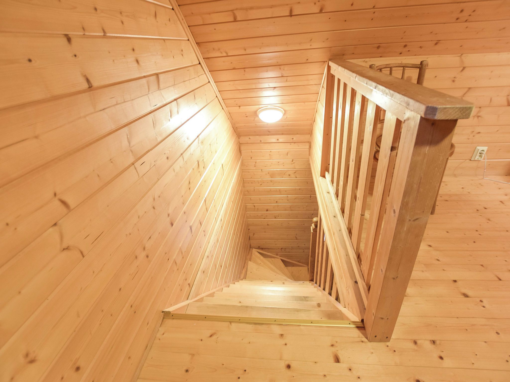 Un escalier en bois menant à un niveau supérieur, avec une rampe également en bois.