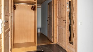 Een houten kamer met een inbouwkast, een bank en een deur met een bijzonder ontwerp.