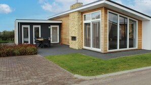 A modern two-story house with a stone facade, large windows, and a patio area. - Ravenbosch+ 5p by Interhome (Bemelen)