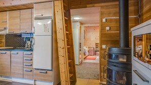 Une cuisine moderne avec des meubles en bois, une cuisinière encastrée et un réfrigérateur visible.