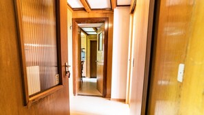 A hallway with wooden doors and a tiled floor. - Bürcher Haus 2. OG Süd by Interhome (Riederalp)