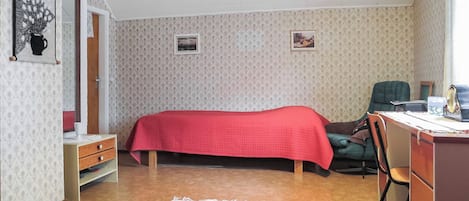 Un dormitorio con una cama, un escritorio, una silla y un aparador.