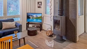 A living room with a television, a fireplace, a sofa, and a coffee table.