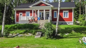 A red house with a porch and a small dock extending into a body of water. - Villa elisabet by Interhome (Ristiina)