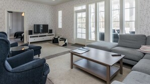 A modern living room with a sofa, armchairs, a coffee table, and a TV on a stand. - Villa elisabet by Interhome (Ristiina)