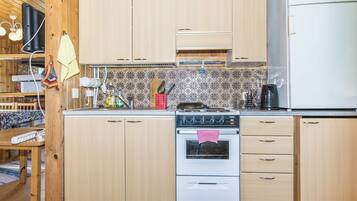 Una cocina con armarios de madera, estufa y refrigerador.