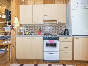 Eine Küche mit Holzausstattung, einem Herd und einem Kühlschrank.