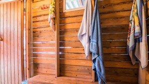 Una sauna de madera con bancos y toallas colgadas en un perchero.
