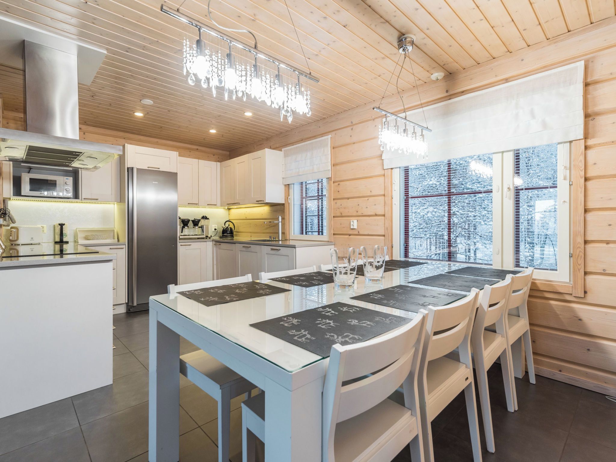 A modern kitchen with a central island, stainless steel appliances, and wooden paneling.