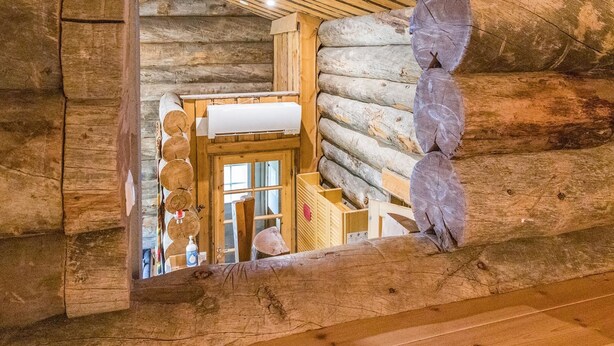 Ein rustikales Blockhaus-Interieur mit einer Holztür, einem Fenster und einer Holzwand.