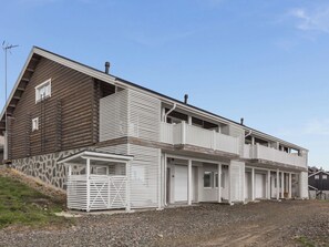 A two-story building with a wooden exterior and white siding, featuring a balcony on the upper floor. - Ylläksen rinnemäki b by Interhome (Ylläsjärvi)