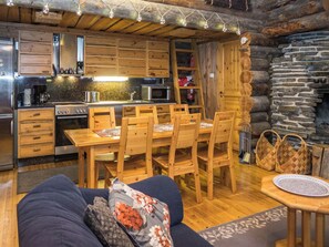 L'intérieur d'un chalet confortable, avec une salle à manger, une cuisine et un coin salon.