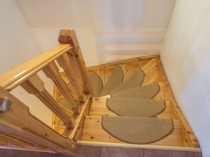 Una escalera de madera con barandilla y piso de madera.