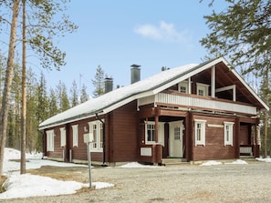 A wooden cabin with a sloped roof, large windows, and a porch. - Hirvas levi 1 by Interhome (Kittilä)