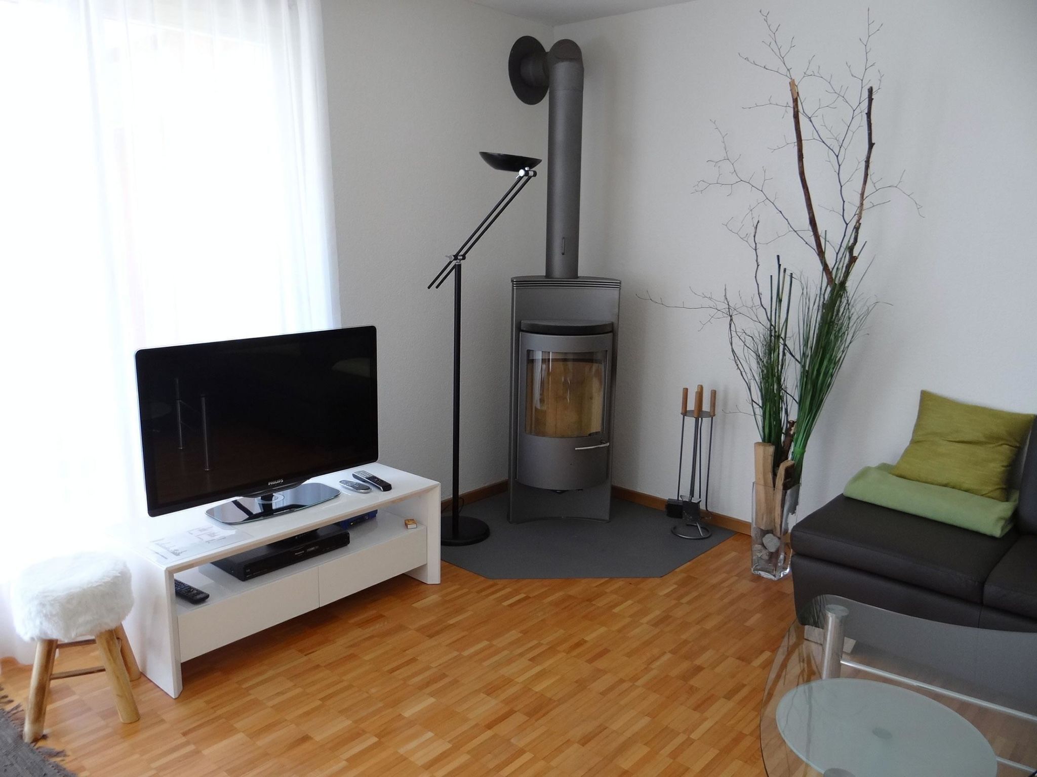 A living room with a flat-screen TV, a fireplace, a sofa, and a coffee table.