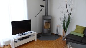 Una sala de estar con una televisión de pantalla plana, una chimenea, un sofá y una mesa de centro.