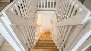 A wooden staircase with white railings leading to an upper floor. - Maahisenrinne 1 as 4 by Interhome (Äkäslompolo)