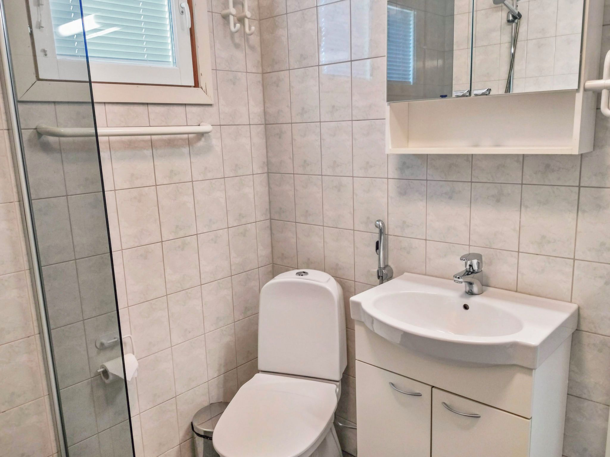 A bathroom with a toilet, sink, and shower.
