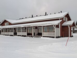 A two-story building with a covered porch and a snow-covered roof.