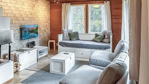 En moderne stue med sofa, tv og pejs.