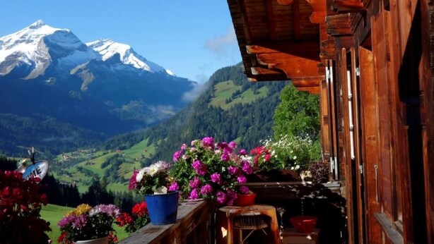 A wooden cabin with a balcony overlooking a mountain range and a clear sky. - Am Bächli by Interhome (Feutersoey)