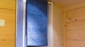 A bathroom with a frosted glass shower door, wooden walls, and a towel hanging on a rack. - Am Bächli by Interhome (Feutersoey)