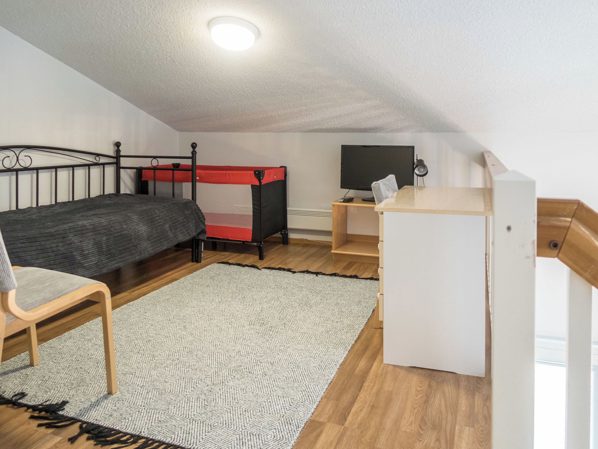 Pieni huone, jossa on kerrossänky, työpöytä, tuoli ja pieni televisio.