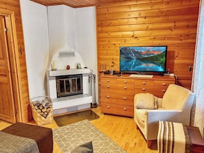Una sala de estar acogedora con chimenea, un televisor montado en la pared y una zona de estar confortable.