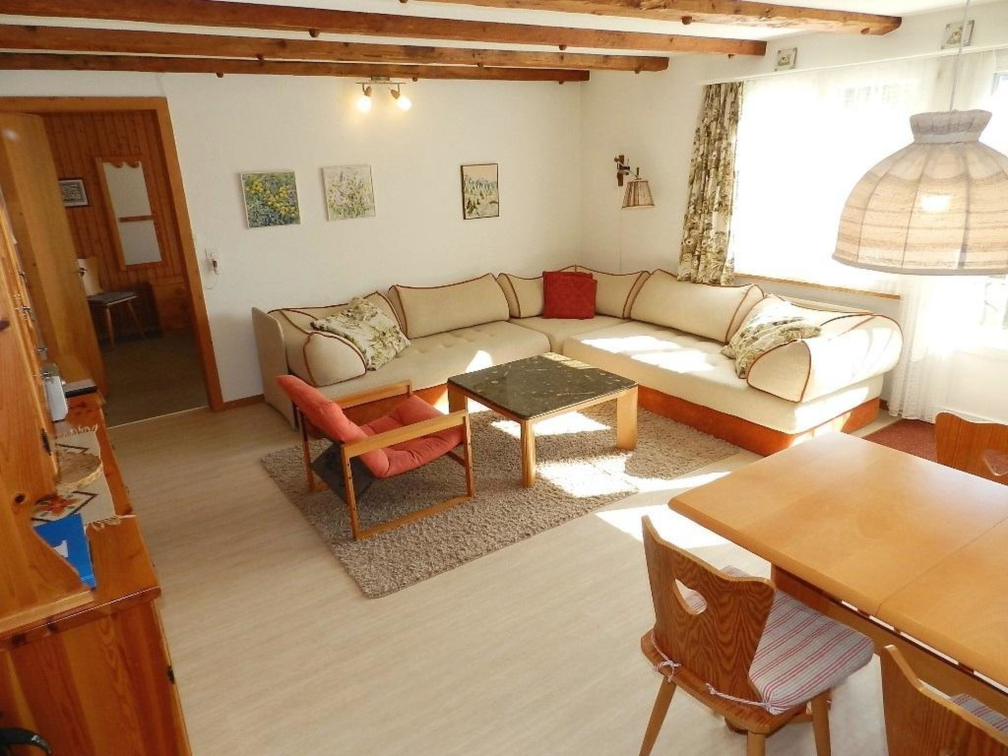 Un salon confortable avec un canapé, deux fauteuils, une table basse et une table à manger.