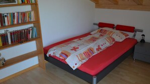 Una camera da letto con un letto, una libreria e un comodino.
