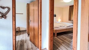 A wooden-framed doorway leading to a bedroom with a bed, a bedside lamp, and a mirror on the wall. - Vergissmeinnicht by Interhome (Dittishausen)