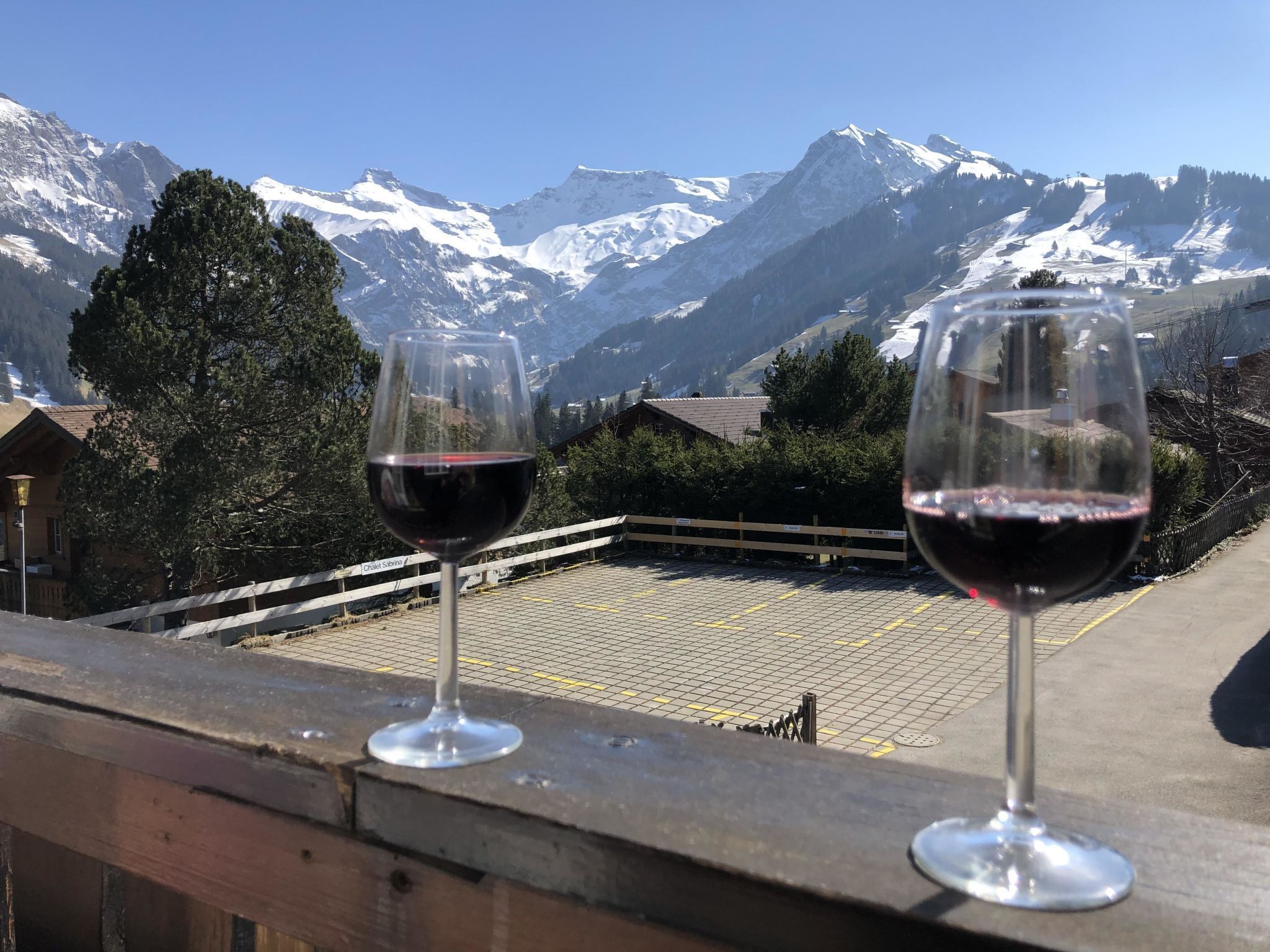 Deux verres à vin sur un balcon avec vue sur la montagne.