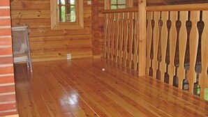 A wooden cabin interior with a wooden floor, a fireplace, and a window. - Mustikka by Interhome (Lohja)