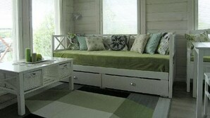 A room with a green sofa, a white desk, and a window with curtains. - Mariantupa by Interhome (Muurame)