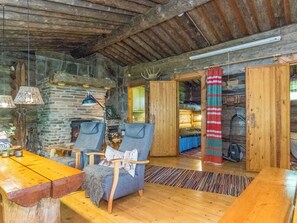 A rustic interior with a stone fireplace, wooden furniture, and a cozy seating area. - Kelo-kolo by Interhome (Iisalmi)