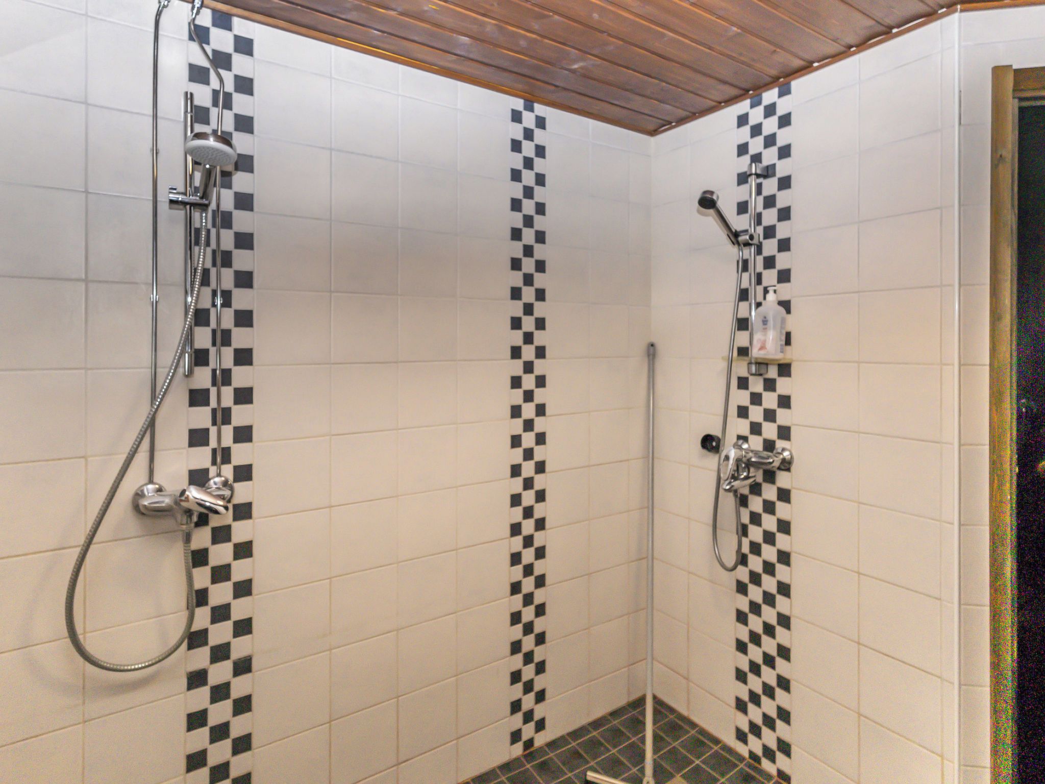 Un espace douche avec des carreaux à motifs et un plafond en bois.