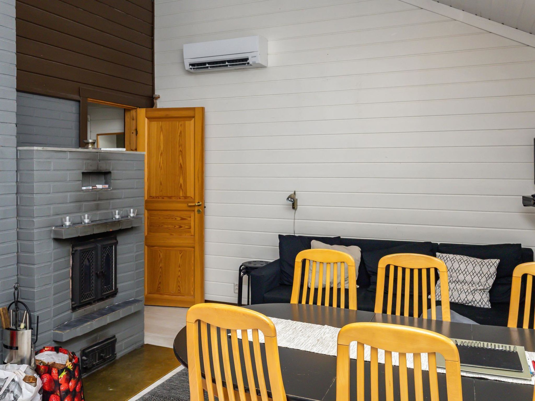 Una habitación acogedora con chimenea, una mesa de comedor con sillas y un sofá.