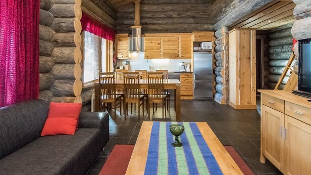 Ein Blockhaus-Interieur mit Essbereich, K üche und Wohnzimmer.