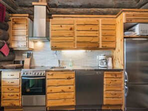 A kitchen with wooden cabinets, a stainless steel refrigerator, a dishwasher, and a stove.