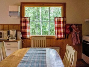 A small kitchen with a window, a microwave, a kettle, and a stove. - Nokikana 7 by Interhome (Parainen)