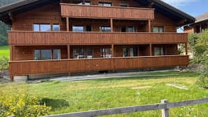 A multi-story wooden chalet with balconies, set in a lush green landscape. - Mösli (Zimmerli) by Interhome (Zweisimmen)