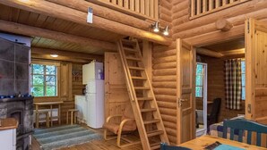 A log cabin interior with a kitchen, dining area, and a staircase leading to a loft. - Salmela by Interhome (Puumala)