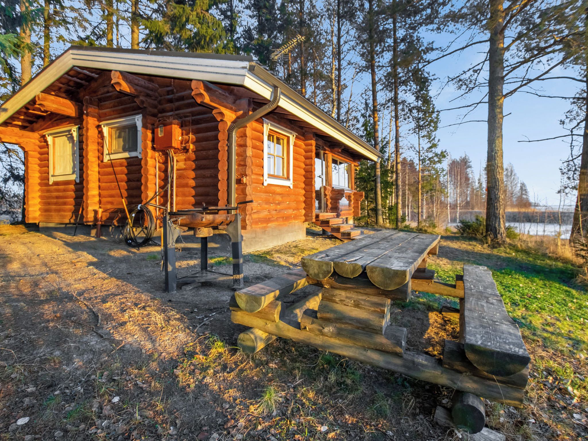 A log cabin with a picnic table and a bicycle parked outside.
