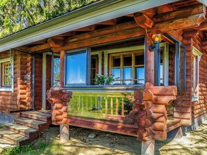 A log cabin with a porch, large windows, and a wooden railing. - Huvilakoti 2 by Interhome (Liperi)