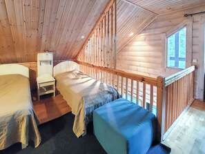 A cabin with two beds, a small table, and a window.