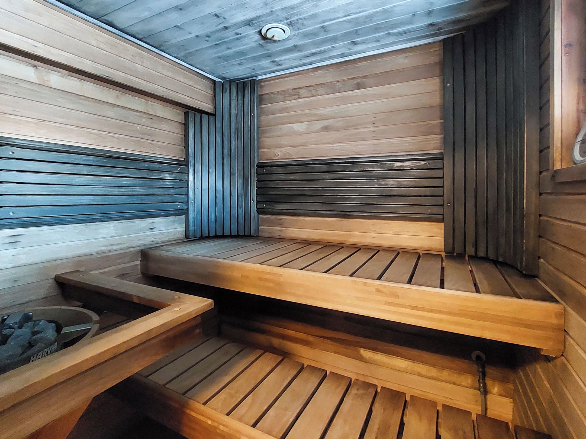 A sauna with wooden benches and a stone bench.