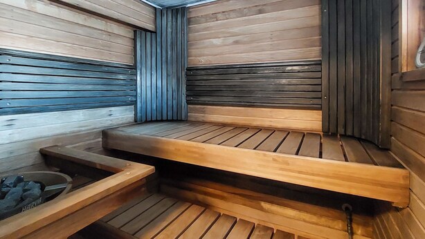 Un sauna avec des bancs en bois et une banquette, une banquette avec une banquette, et une banquette avec une banquette.
