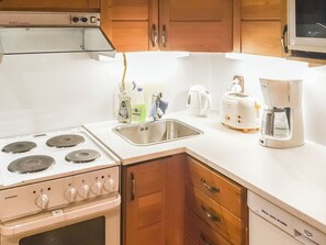 Een keuken met een Siemens fornuis, een spoelbak, een Bosch koffiezetapparaat en een Siemens vaatwasser.