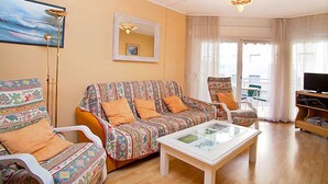 A living room with a sofa, armchairs, a coffee table, a TV, and a painting on the wall. - Edificio Blanqueries by Interhome (Calella)