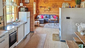 Un acogedor interior de cabaña con cocina, comedor y sala de estar.